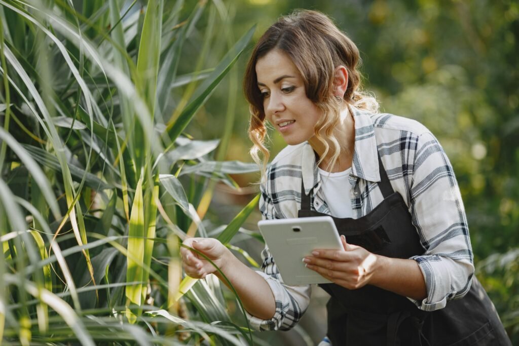 Farmers using compost while checking soil data on a tablet.