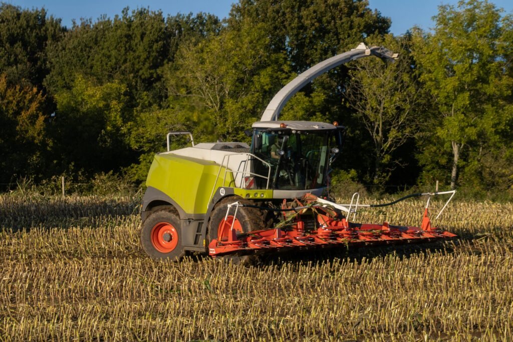 Modern tractor plowing a lush green field under a clear sky, symbolizing resilient and sustainable UK farming practices.